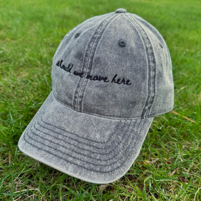 Gray denim travel themed cap with text "should we move here" on grass