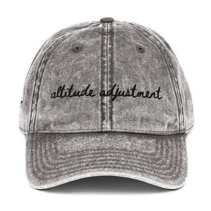 Vintage wash grey travel themed hat with words "altitude adjustment" on it