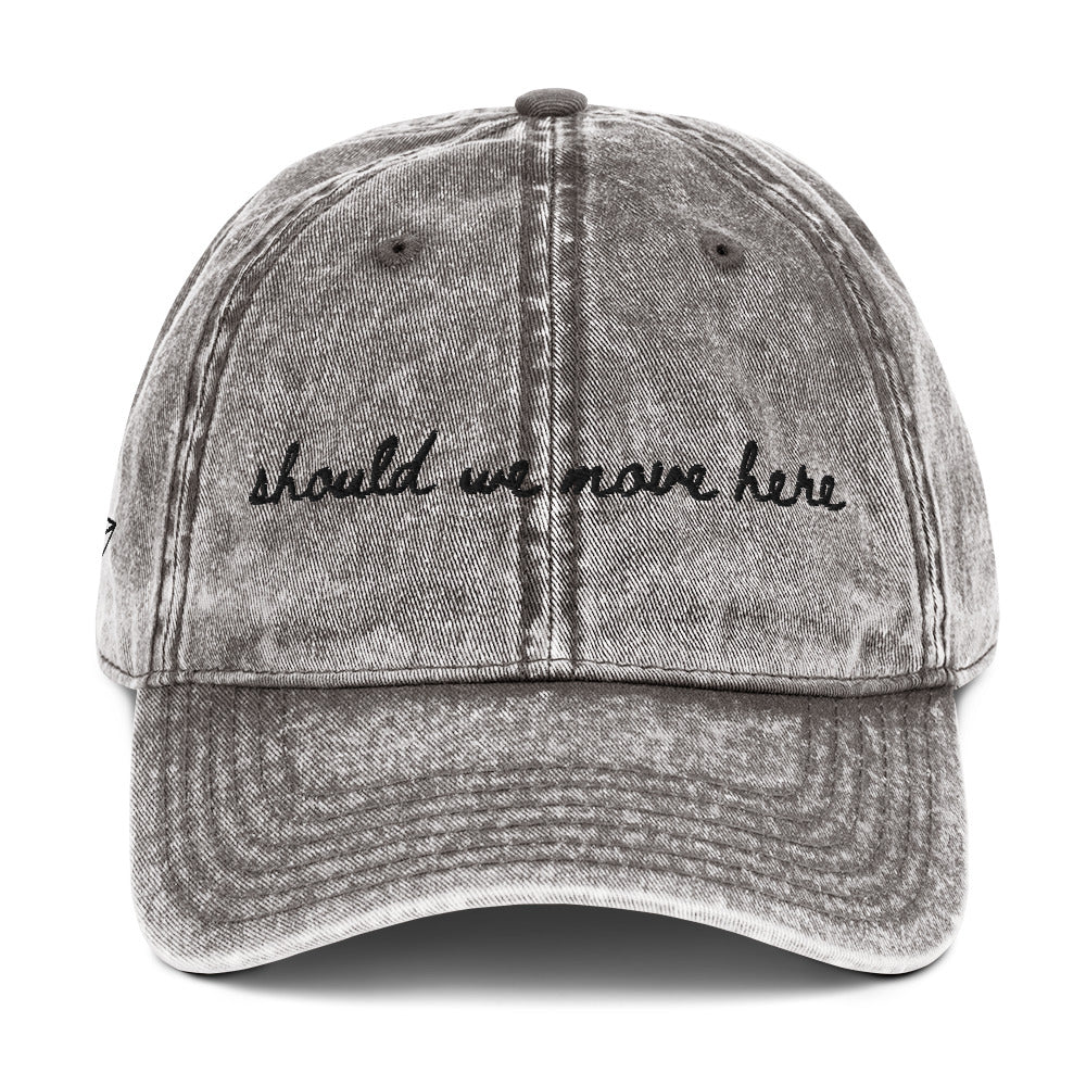 Vintage wash grey travel hat with the words "should we move here" embroidered on it 