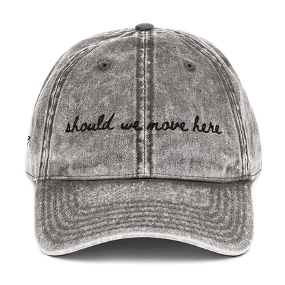 Vintage wash grey travel hat with the words "should we move here" embroidered on it 